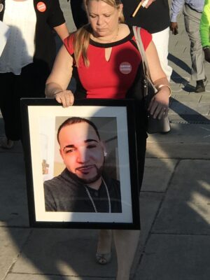 Aleida holds an image of her son Alex
