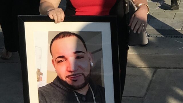 Aleida holds an image of her son Alex