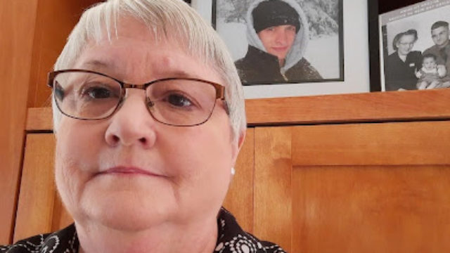 Dorothy takes a selfie in front of her son and father