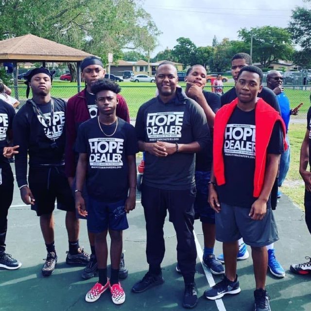 A group of about 10 pen stand together while wearing Hope Dealer tshirts