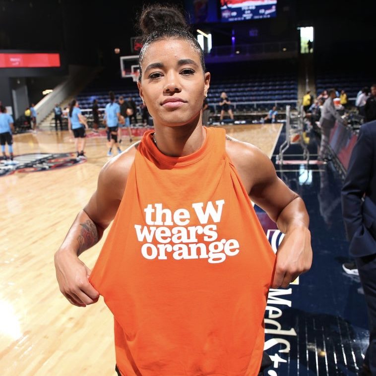 WNBA player Natasha Cloud shows off her Wear Orange shirt on the basketball court