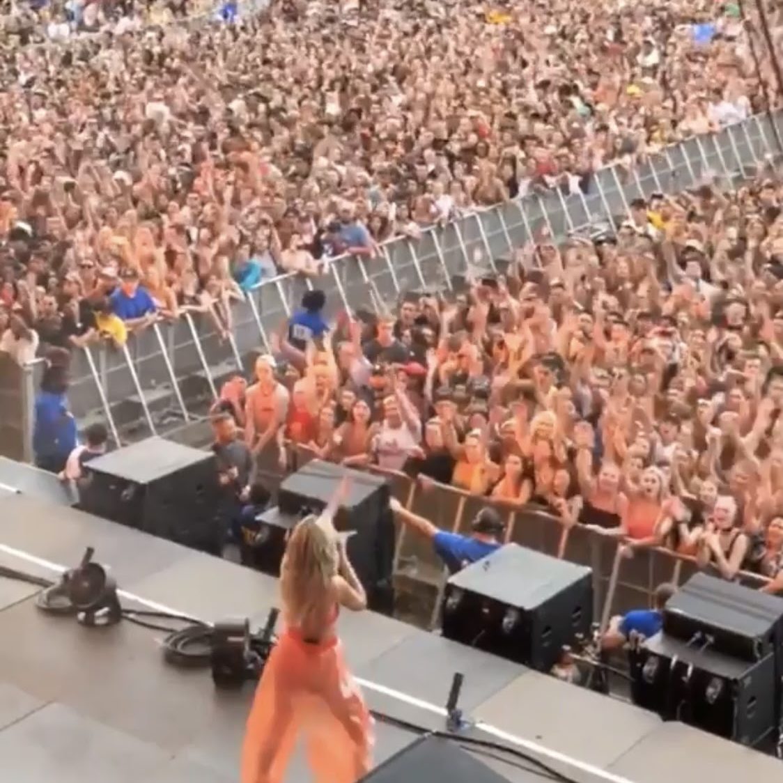 Halsey performs on stage to a crowd full of orange shorts at Gov Ball