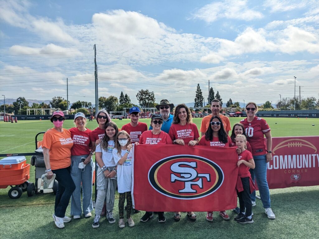 Moms Demand Action volunteers pose for a photo with a San Francisco 49ers banner