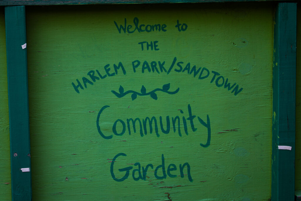 A sign that says “Welcome to the Harlem Park/Sandtown Community Garden”