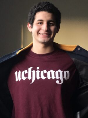 Justin Funez smiles while showing off his uchicago shirt