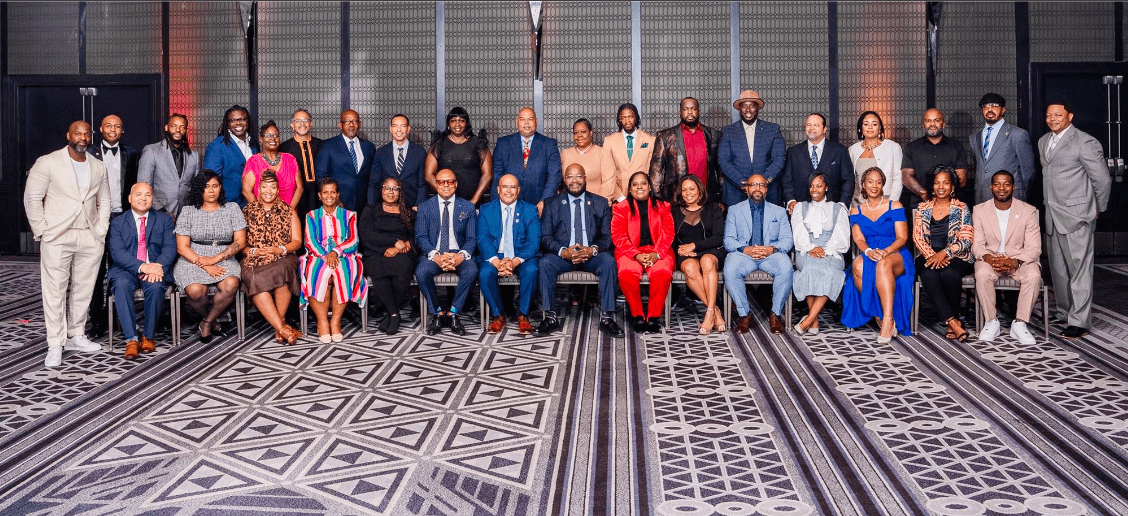 Members of the second cohort of the University of Chicago Lab’s Community Violence Intervention Leadership Academy (CVILA) pose for a photo at the CVILA cohort graduation. 15 cohort members sit on chairs and form the first row of the photo; 19 other cohort members stand behind the chairs, forming a second row.