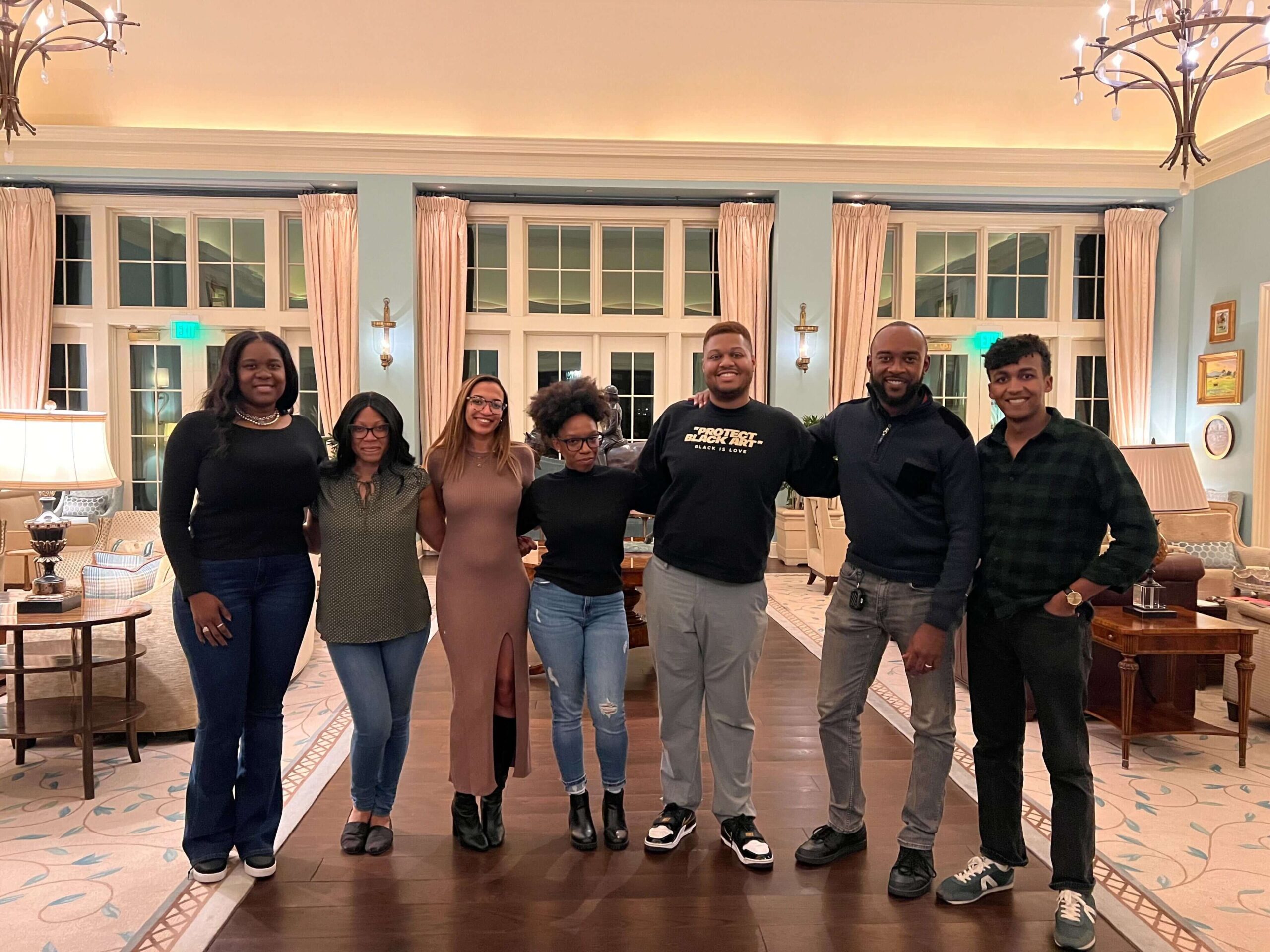 The seven members of the Everytown Community Safety Fund team pose for a photo at a retreat center. They are all wearing semi-casual clothing. 