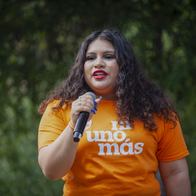 Ashley Castillo wears an orange t-shirt that reads 